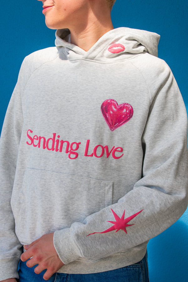 Hoodie front view with lipstick kiss on hood, ballon heart above the text saying "sending love".